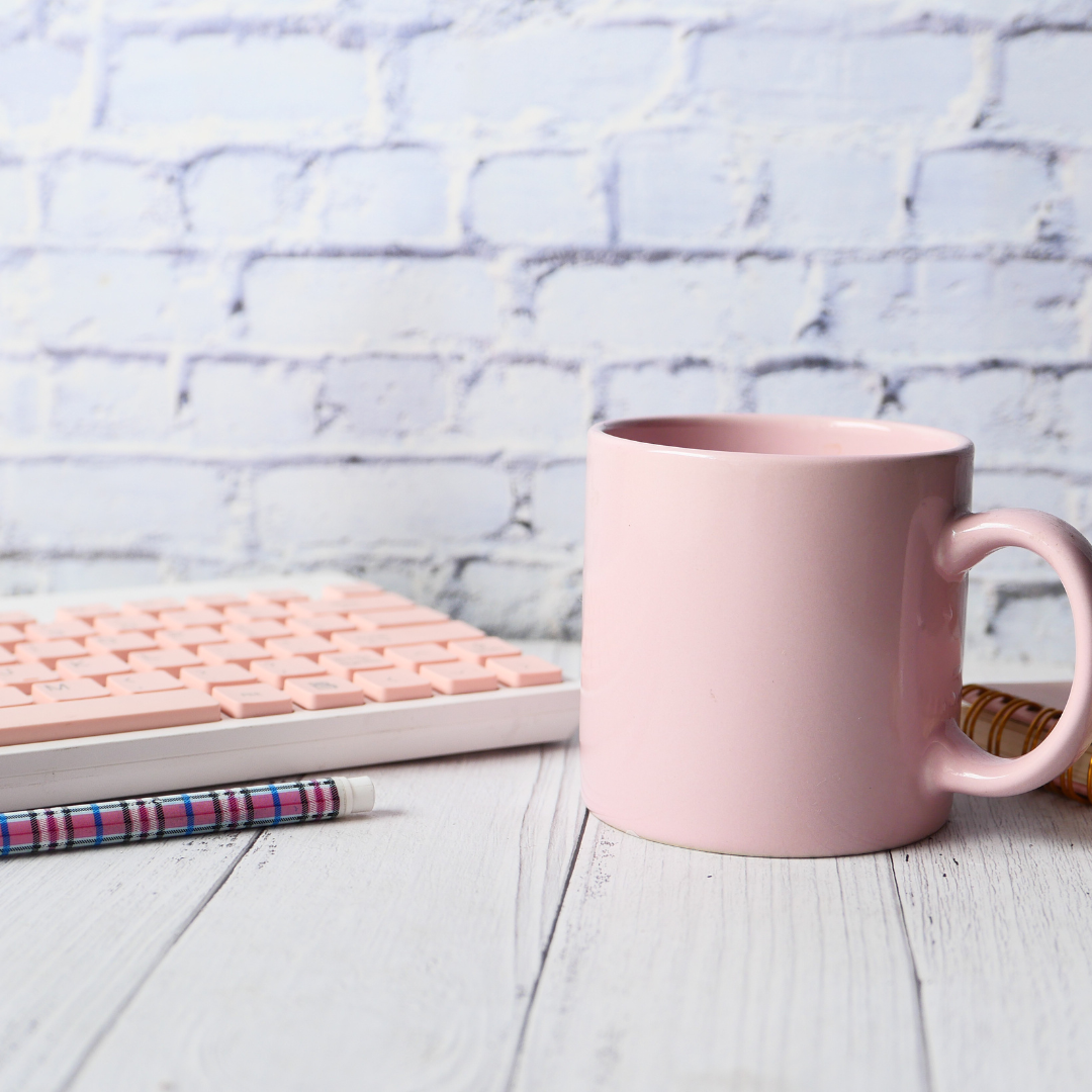 Desk with pink keyboard and pink mug